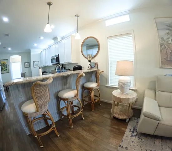 a living room with furniture a mirror and a chandelier