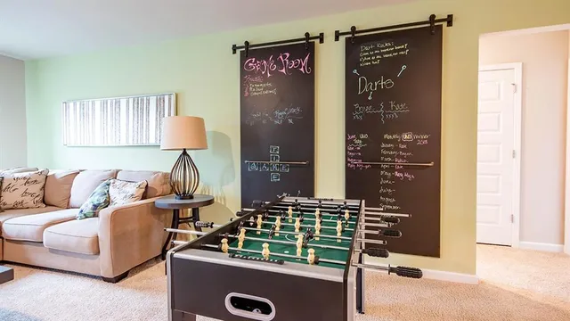 a bedroom with a bed and a lamp on dresser next to a window