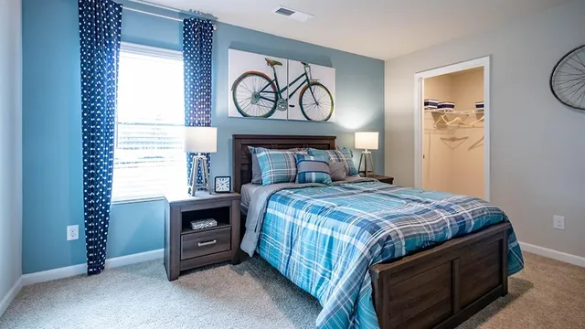 a bedroom with a bed and a dresser in it