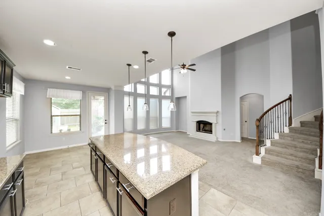 a large living room with a fireplace and large windows