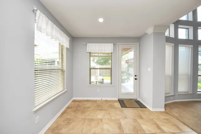 a view of an empty room with a window and a bathroom