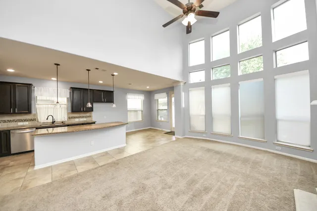 a view of a kitchen with kitchen island a sink and a large window