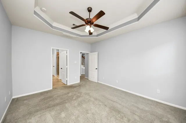 an empty room with ceiling fan and window