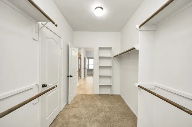 a view of a hallway with closet and bathroom