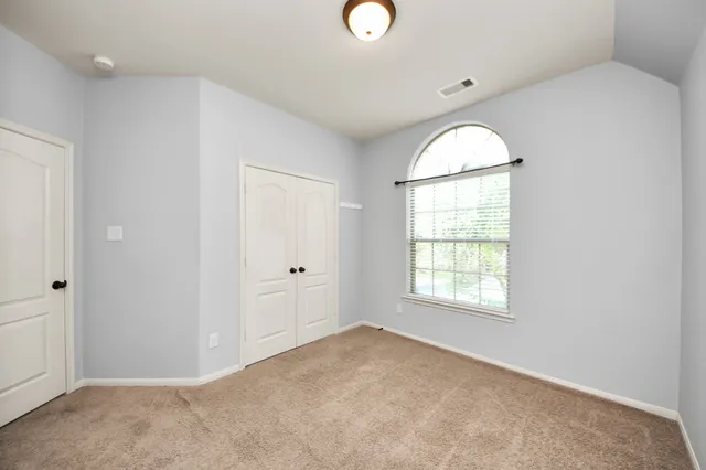 an empty room with windows and mirror