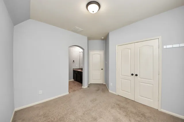 an empty room with closet and mirror