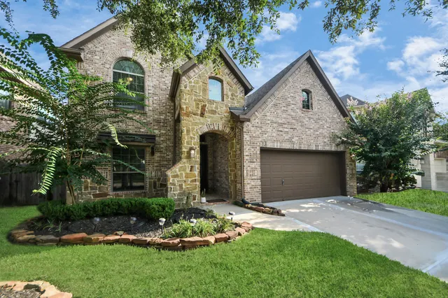 a front view of a house with a garden and yard