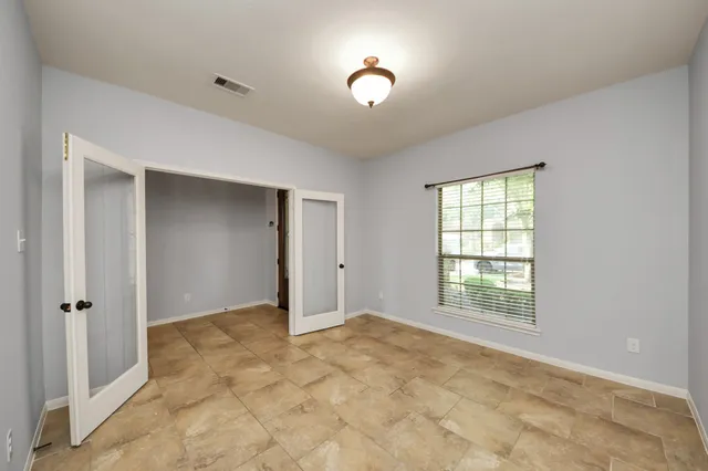 an empty room with windows and closet
