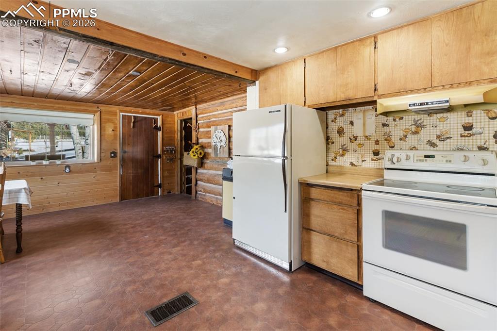 2300 Rampart Range Road Woodland Park, CO 80863 - Photo 14 of 45 a kitchen with white cabinets and white appliances