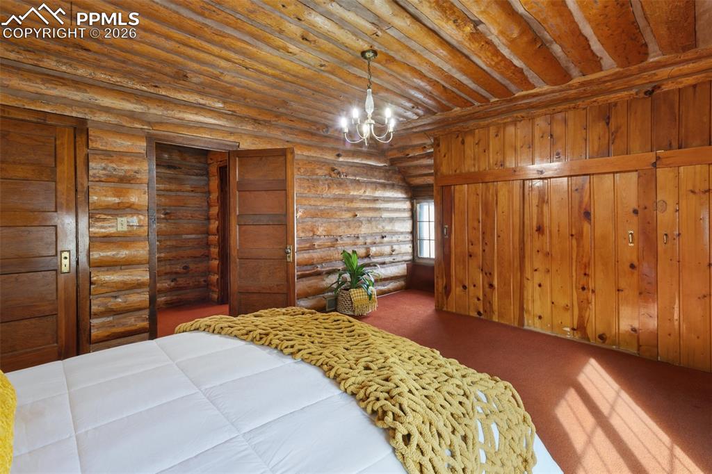 2300 Rampart Range Road Woodland Park, CO 80863 - Photo 29 of 45 a bedroom with a bed and a chandelier