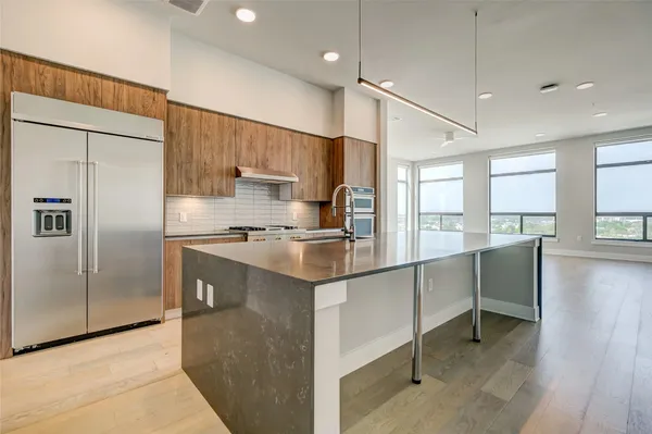 a kitchen with kitchen island a counter top space appliances and a window