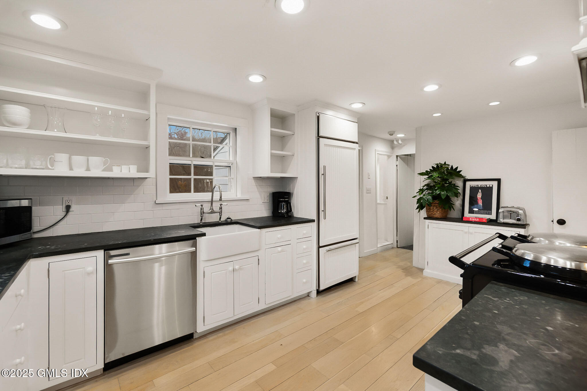45 Burying Hill Road, Unit COTTAGE Greenwich, CT 06831 - Photo 7 of 19 a kitchen with a sink and white cabinets with wooden floor