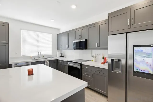 a kitchen with stainless steel appliances a refrigerator sink and cabinets