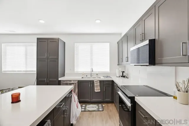 a kitchen with a sink a stove and cabinets