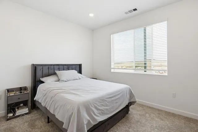 a bedroom with a bed and a window