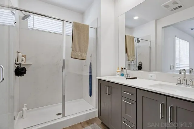 a bathroom with a shower sink and mirror