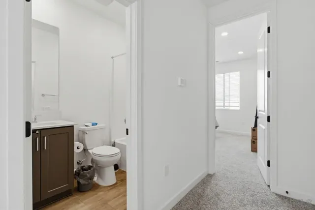 a bathroom with a granite countertop toilet and a sink
