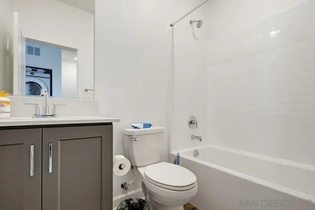 a bathroom with a granite countertop toilet a sink and a bathtub