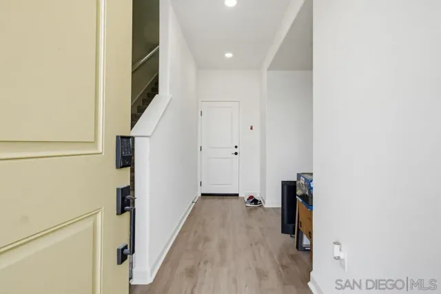 a view of hallway with stairs and wooden floor