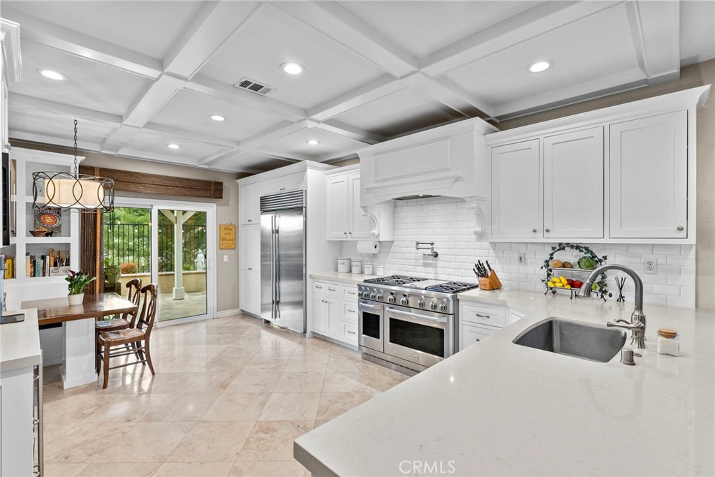 29859 Cashmere Place Castaic, CA 91384 - Photo 15 of 48 a kitchen with stainless steel appliances a stove a sink a oven a dining table and chairs with wooden floor