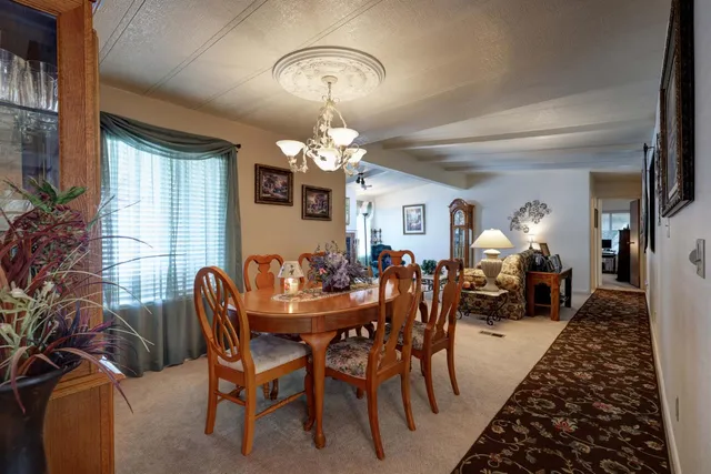 a view of a dining room with furniture and a chandelier