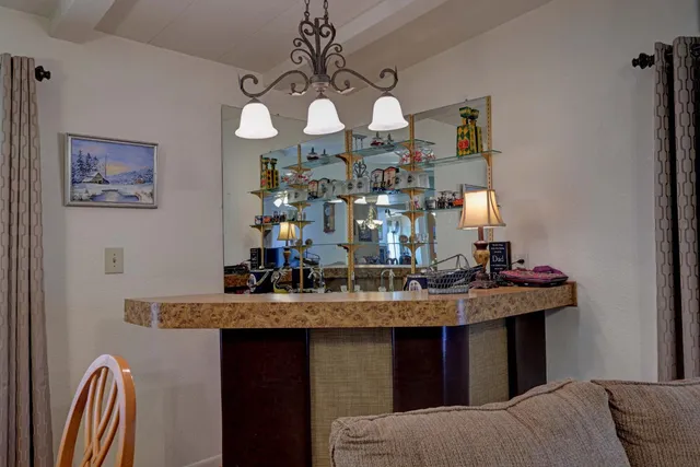 a living room with furniture kitchen view and a large window