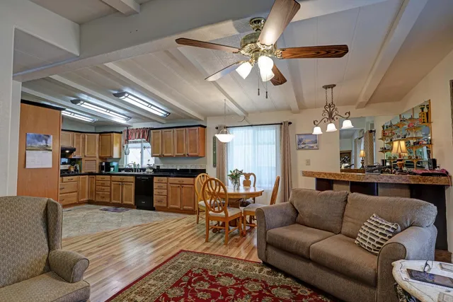a kitchen with granite countertop a dining table chairs stainless steel appliances and cabinets