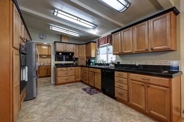 a kitchen with stainless steel appliances granite countertop a refrigerator and a sink