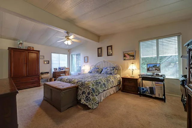 a bedroom with a large bed and dresser with mirror