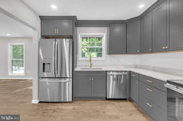 a view of an empty room with a window and a kitchen