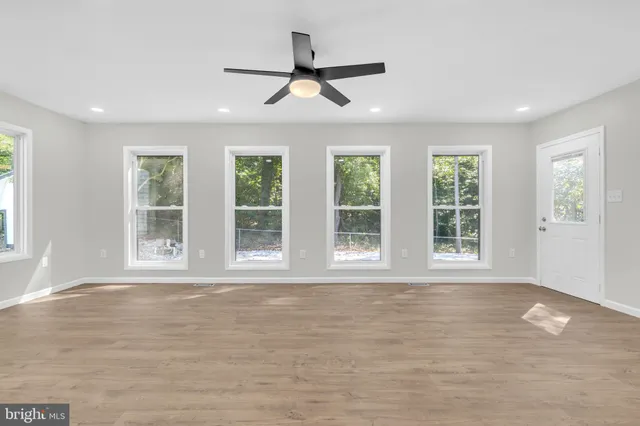 an empty room with closet and fan