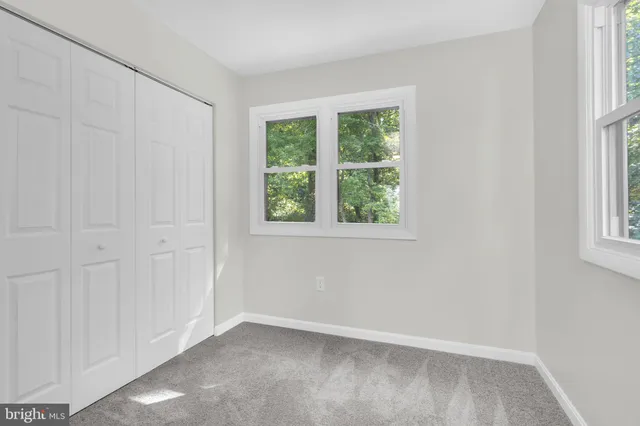 an empty room with a ceiling fan and a window