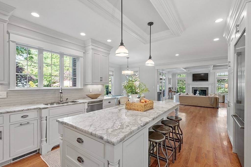 25 Shade Street Lexington, MA 02421 - Photo 19 of 42 a kitchen with stainless steel appliances granite countertop a stove a refrigerator a sink a dining table and chairs with wooden floor
