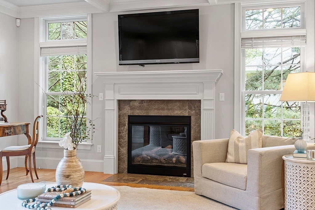 25 Shade Street Lexington, MA 02421 - Photo 9 of 42 a living room with furniture a flat screen tv and a fireplace