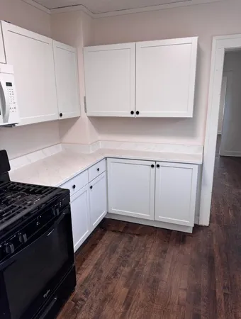 a kitchen with granite countertop white cabinets and white appliances