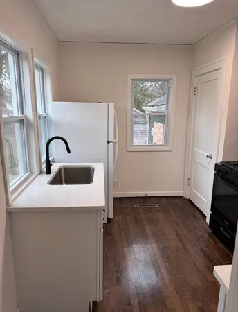 a view of a sink and dishwasher with wooden floor