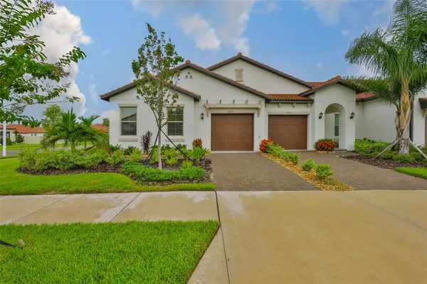 a front view of a house with a yard and potted plants