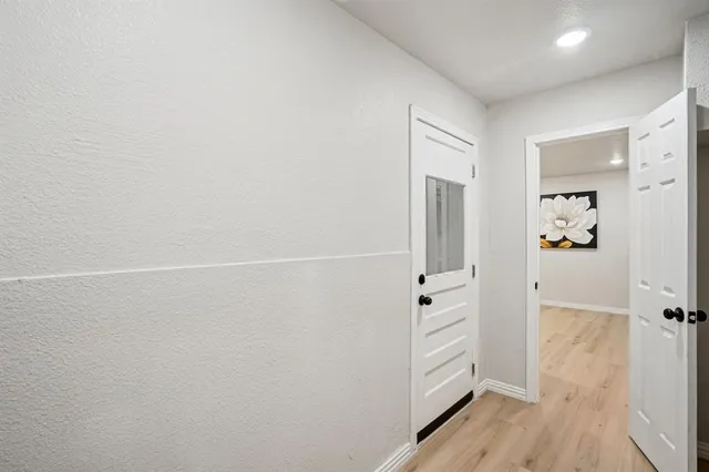 an empty room with wooden floor and cabinet