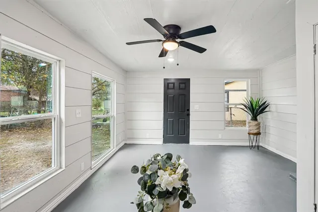 a view of empty room with wooden floor and fan