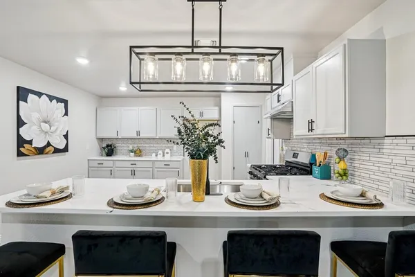 a kitchen with stainless steel appliances granite countertop a sink and stove
