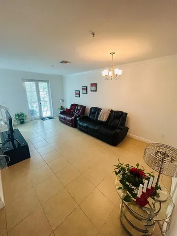 a living room with furniture and a chandelier