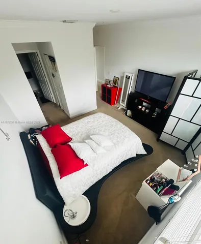 a bed sitting in a bedroom next to a lamp with rug and a lamp