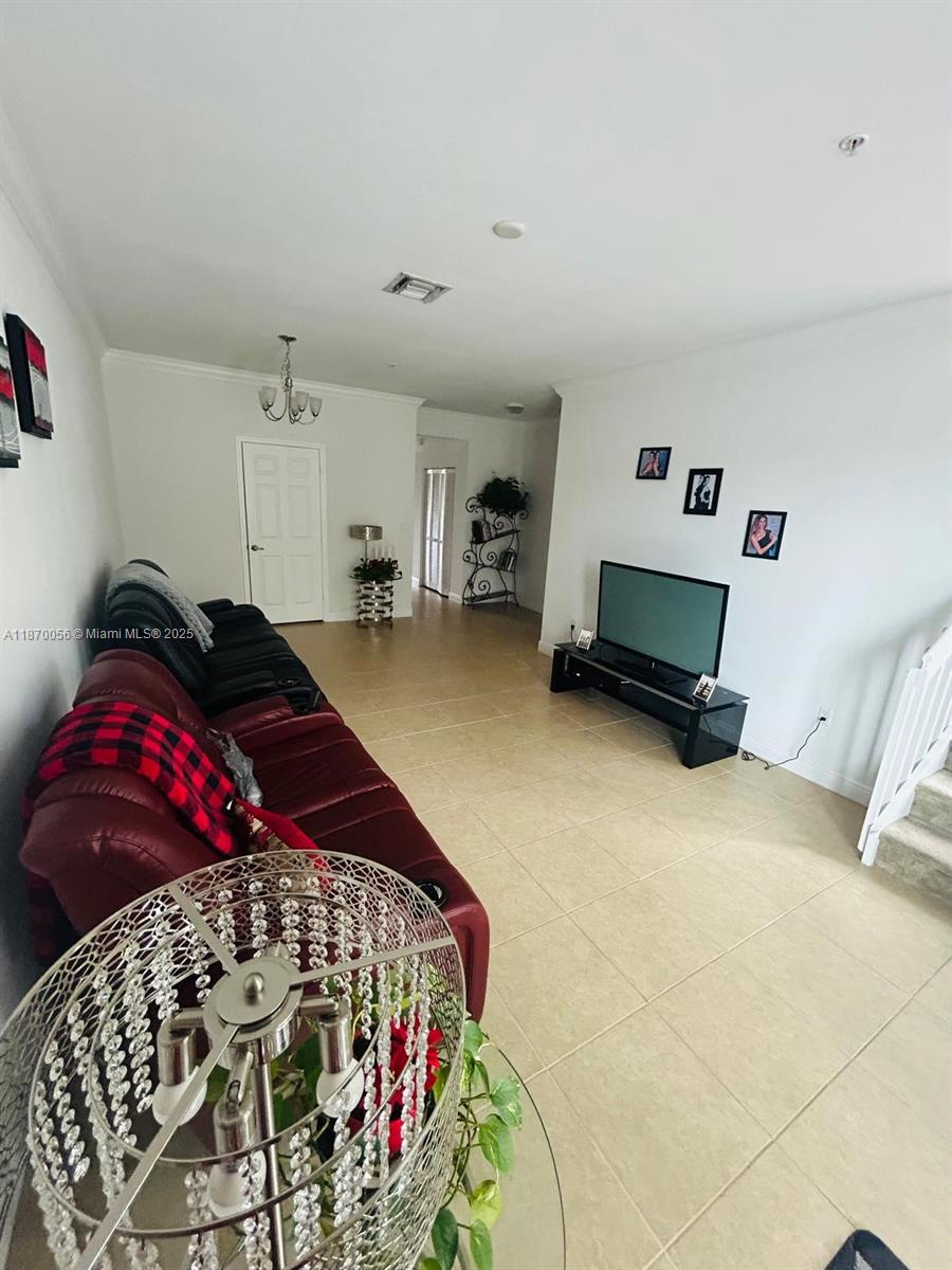 819 Southwest 147th Avenue, Unit 1405 Pembroke Pines, FL 33027 - Photo 25 of 31 a bedroom with a bed and a chandelier