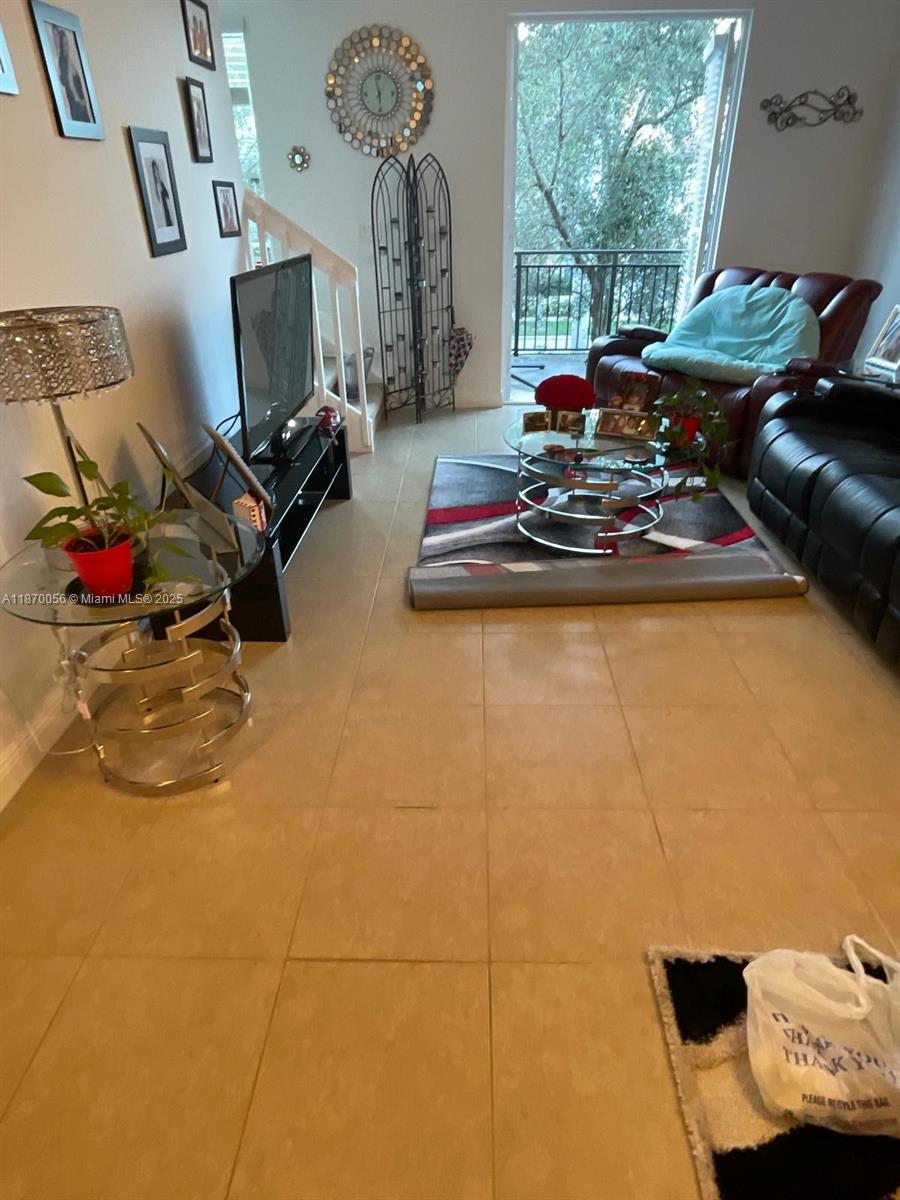 819 Southwest 147th Avenue, Unit 1405 Pembroke Pines, FL 33027 - Photo 7 of 31 a living room with furniture and a flat screen tv