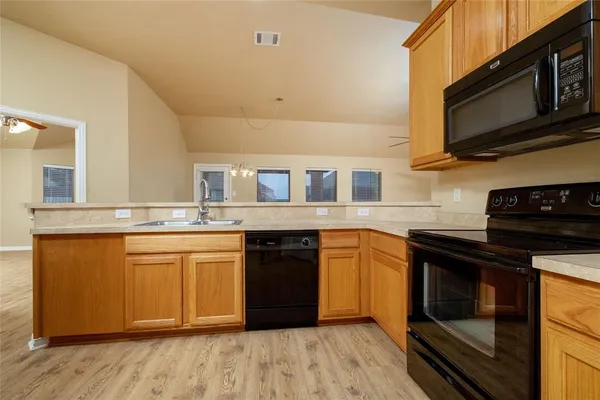a kitchen with stainless steel appliances granite countertop a stove a sink and a microwave
