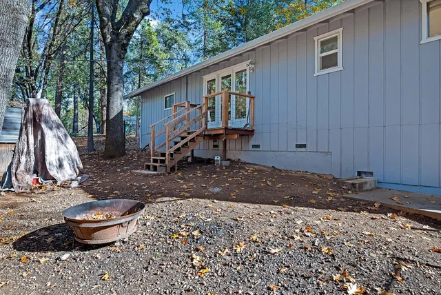 a view of a backyard with table and chairs and wooden fence