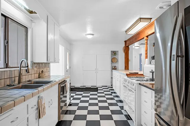 a kitchen with a sink a stove a refrigerator and cabinets