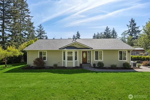 a front view of a house with a garden and trees