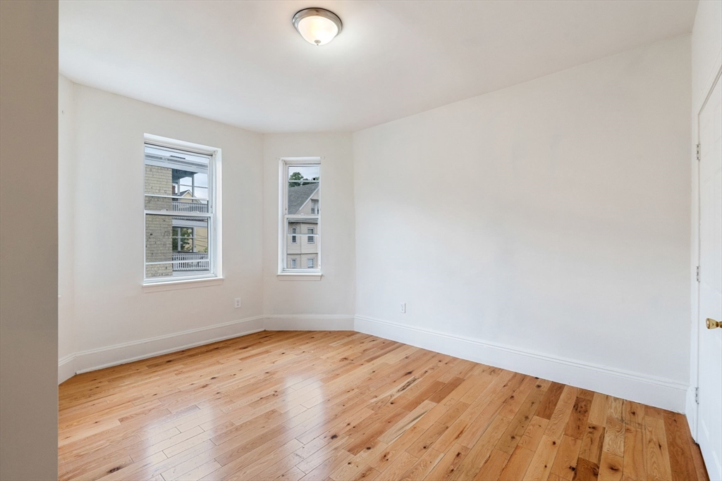 80-84 Shepton Street, Unit 803 Boston, MA 02124 - Photo 2 of 16 an empty room with wooden floor and windows