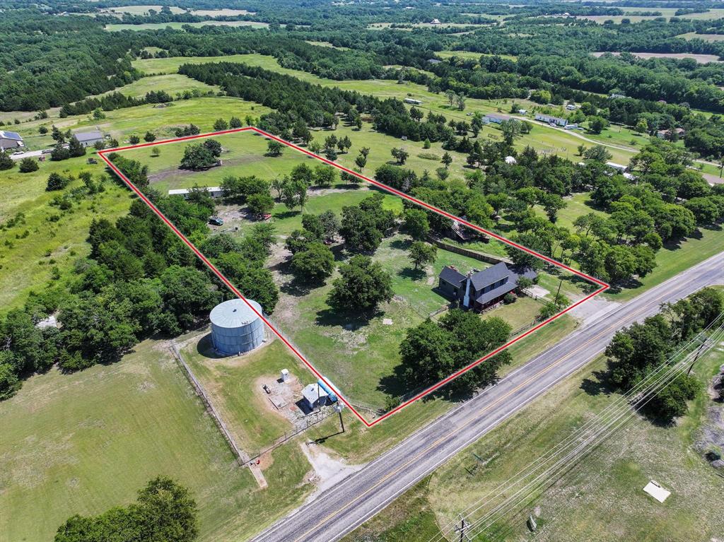 4453 Farm To Market 902 Howe, TX 75459 - Photo 20 of 40 Expansive rural property featuring a main residence, mature trees, open green spaces, a water tower, and a paved road frontage